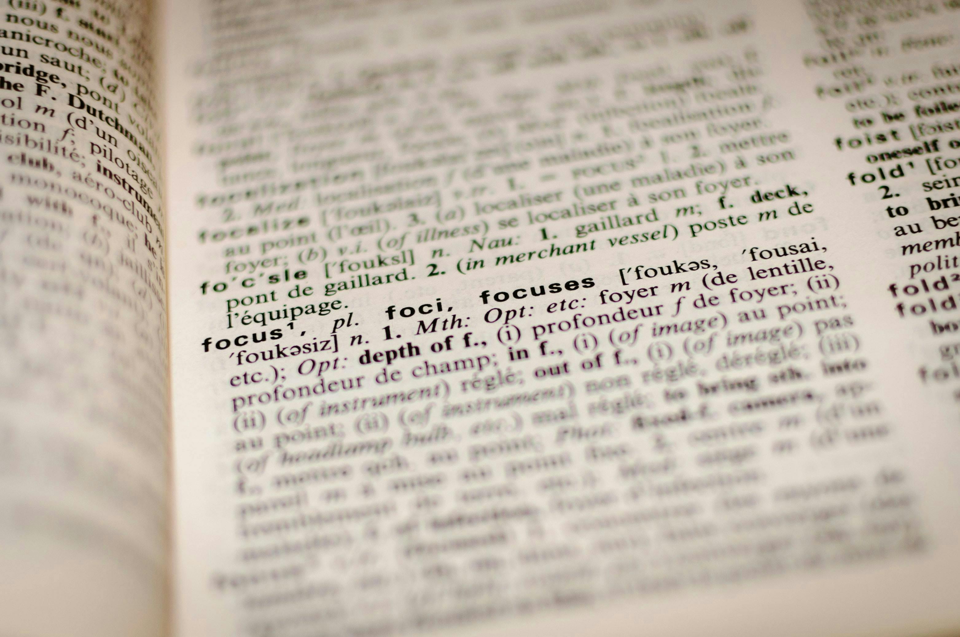 Open dictionary displaying the definition of "focus" in English and French, highlighting the word in bold text within a page full of other entries and definitions.