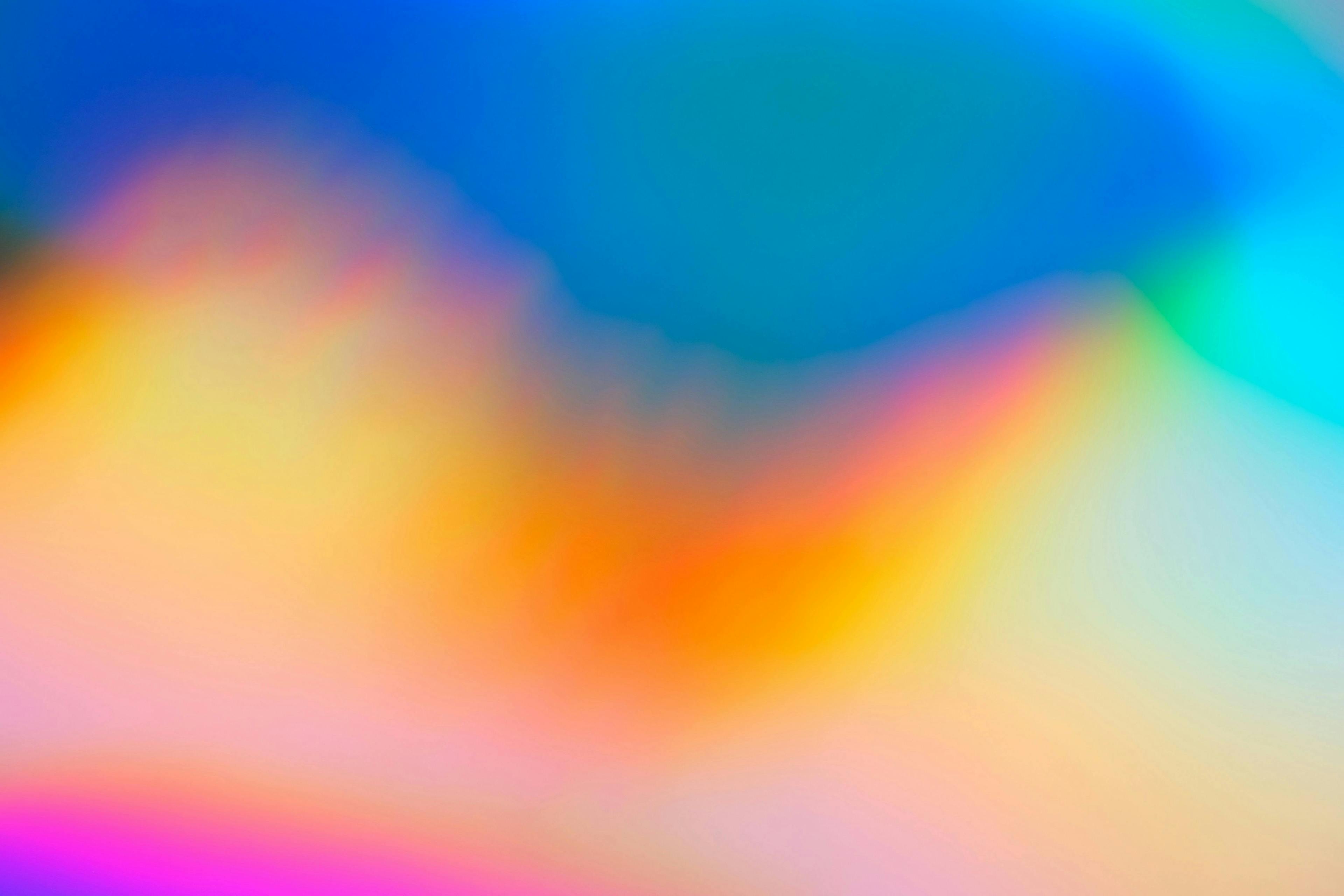 Abstract color gradient transitioning from deep blues to warm oranges, with magenta and yellow tones blending smoothly across the image, evoking a serene and vibrant atmosphere.