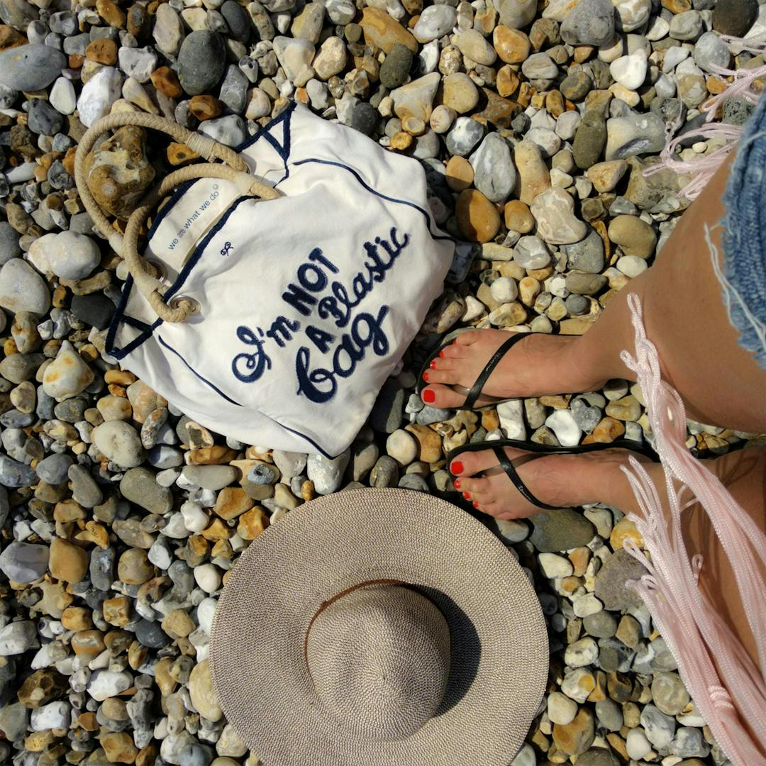 image of feet, a hat, and a bag at a rocky place