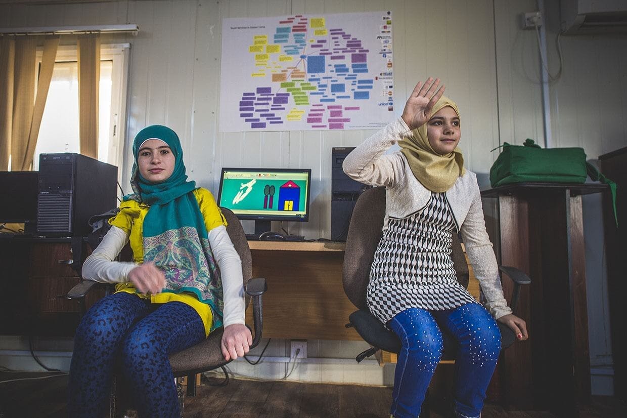 Image of two young women inside a computer classroom