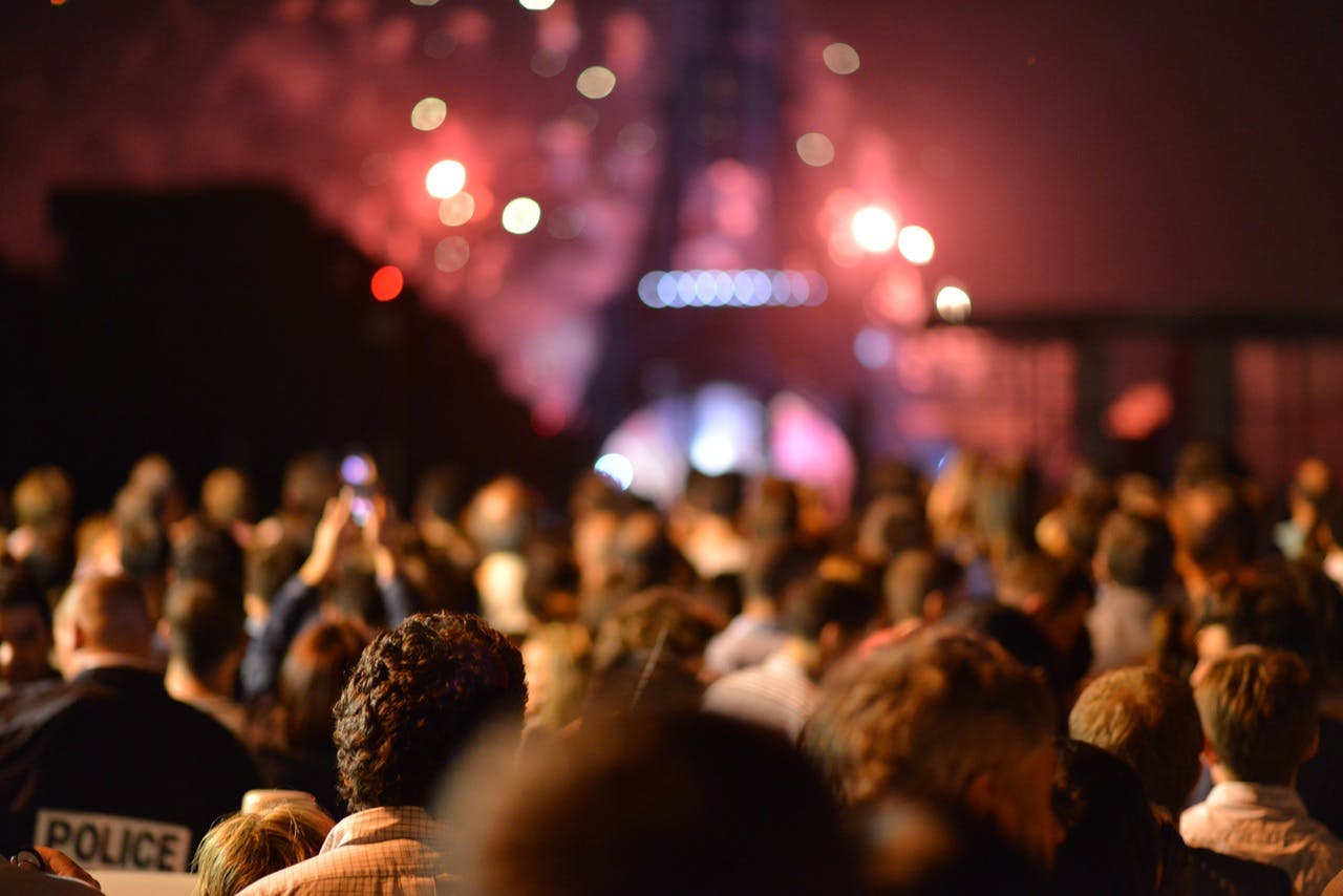 crowd at night surrounding Eiffel Tower