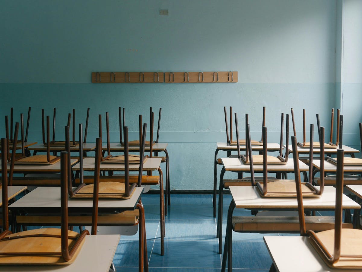 An empty classroom with chairs perched on desks