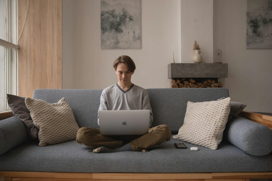 man sitting on a couch with his laptop