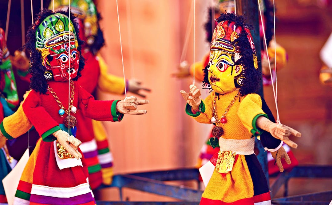 Two Bommalattam puppets, traditional Indian marionettes, tied by strings