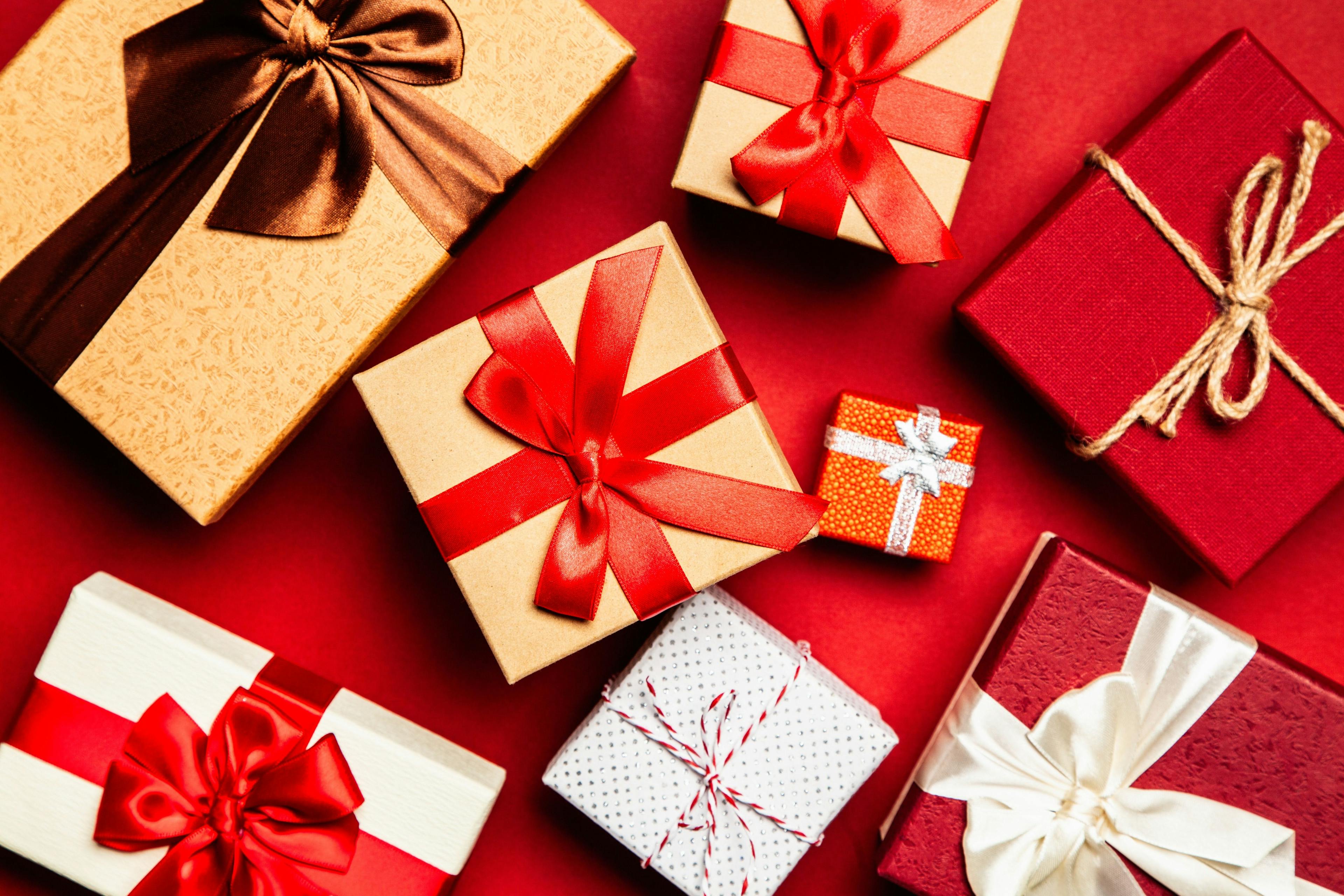 assortment of red, white, and brown gift boxes with a red background