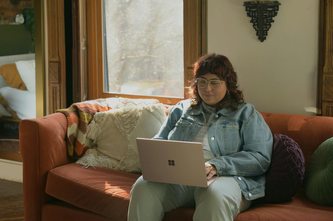 a woman on the couch using her laptop
