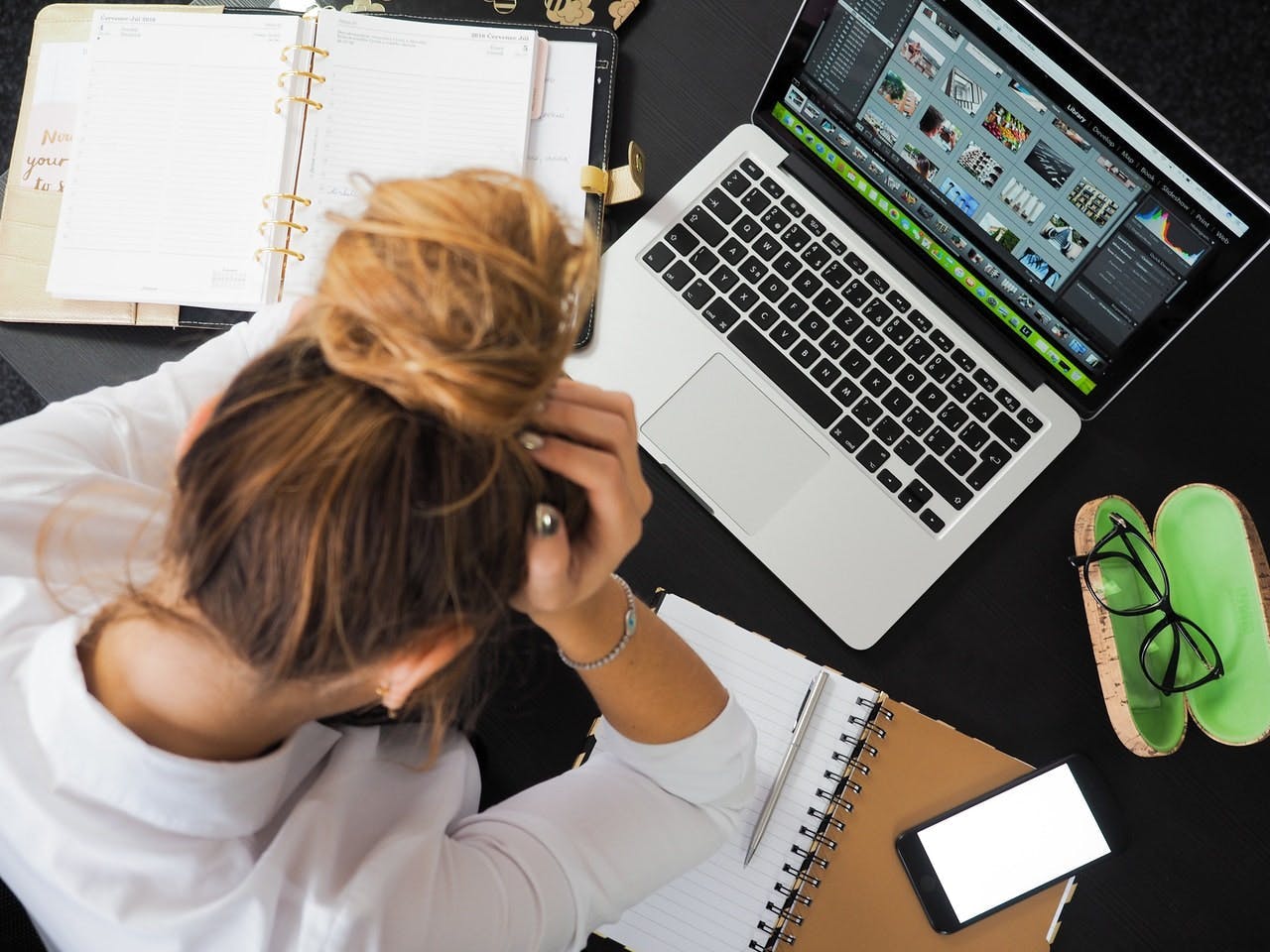 woman who looks stressed while in front of a laptop