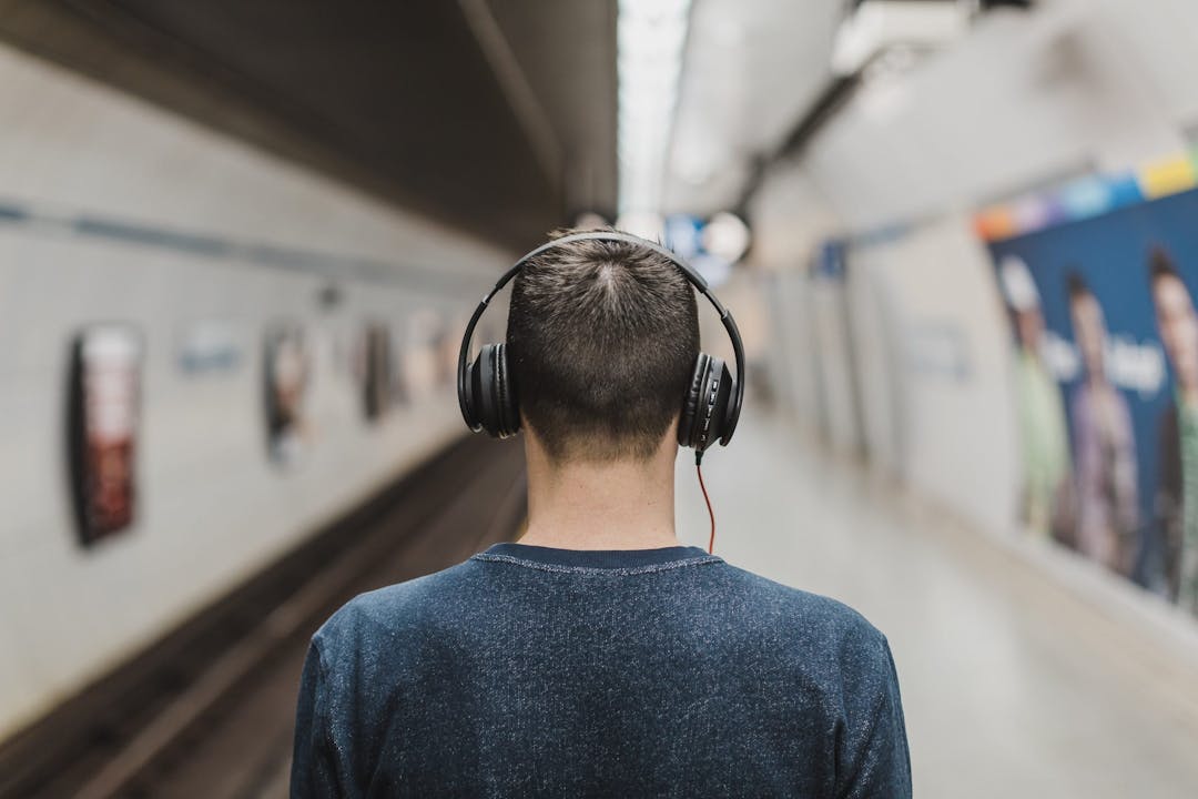 man wearing headphones in train station
