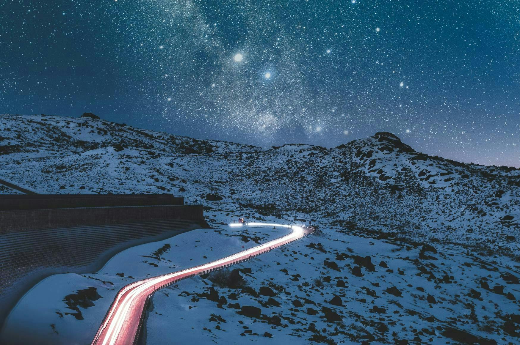 mountains and night sky with lit road